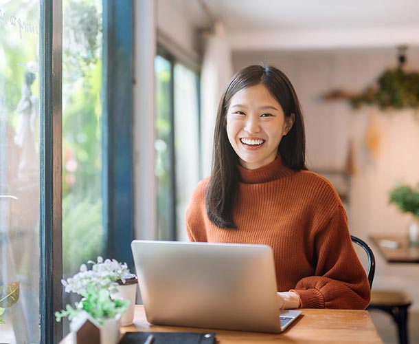 smiling woman on a laptop at home